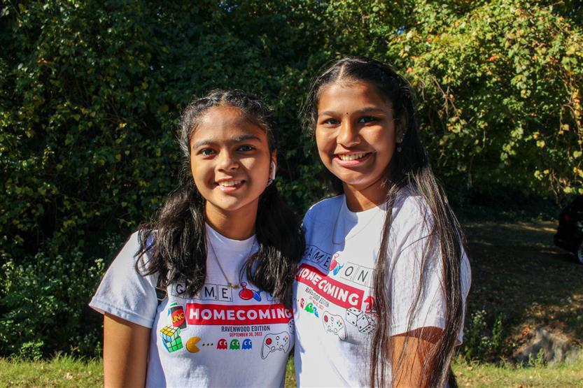 Two girls wearing white shirts smile